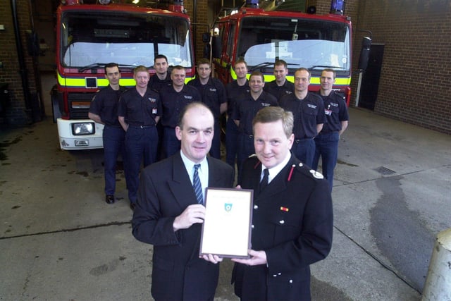Billy Halligan, left, was presented with a Chief Fire Officer's Commendation by Assistant Chief Fire Officer Allan Hughes, right, at Bramley Fire Station in February 2001 Looking on behind are firefighters from Red Watch who attended the fire at the Barley Corn pub where Billy saved landlady Susan Hanlon.