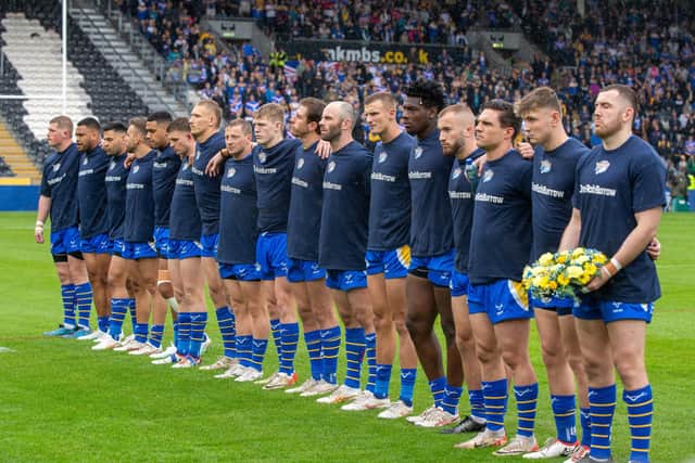 Leeds Rhinos players line up before the game at Hull FC, with captain Cameron Smith carrying a wreath in memory of Rob Burrow. Picture by Bruce Rollinson.