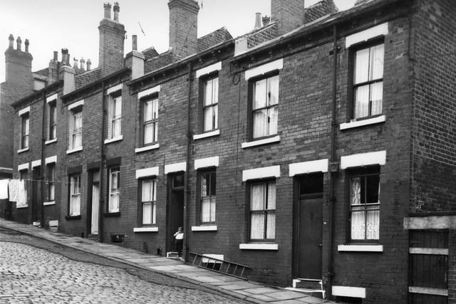 A child stands in the doorway of a house on Melville Street in August 1965. This photo taken prior to slum clearance.