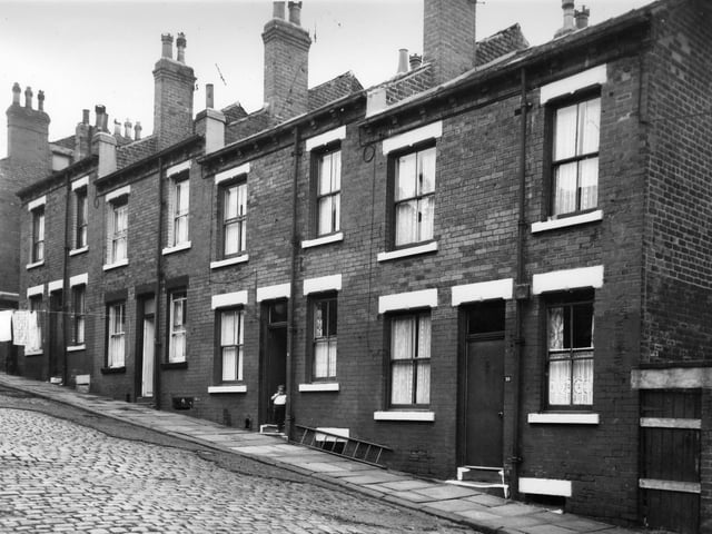 A child stands in the doorway of a house on Melville Street in August 1965. This photo taken prior to slum clearance.