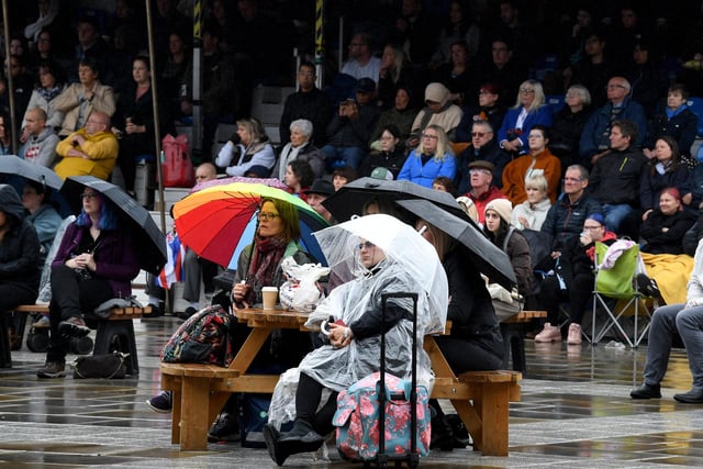 Mourners huddled under umbrellas as they watched the service