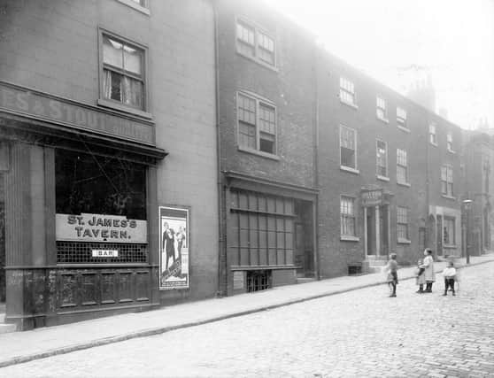 St James Street looking north in August 1913. On the left at number 74a is St James tavern with the empty premises of Charles Thomas, former dining rooms at 72. Oxford hand laundry (prop: Mrs Porritt) can be seen to centre of photograph at 72. Children stand on cobbled road.