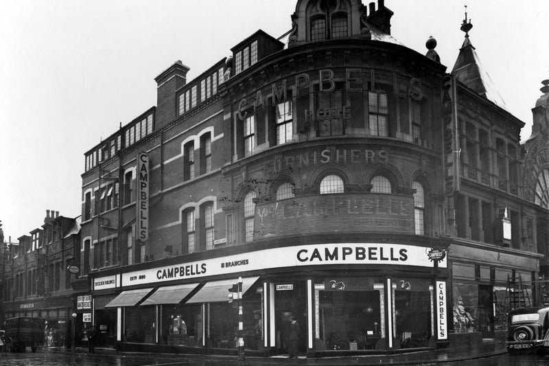 Lands Lane with the junction with The Headrow in June 1936. On the corner is J F Campbells Home Furnishing, then Taylor N Sweets, then Stanley's drapers.
