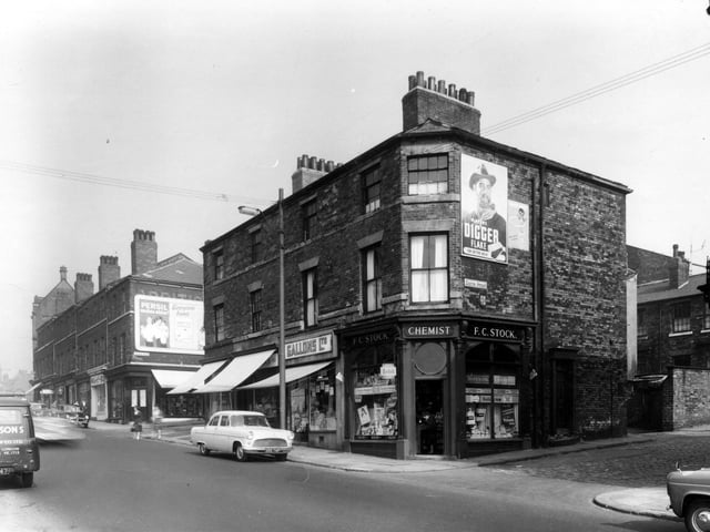 Woodhouse Lane in August 1959. In the centre are four shops, to the left, at the corner with Exeter Place is number 112 Woodhouse Lane. This is Eric Peel butcher, the sun blind is pulled down to shade the window. Next right 110 is D. Addyman, pork butcher, again the blind is down. At 108 is a branch of Gallons Ltd, grocers. On the right at the corner with Exeter Street is Frank Claude Stock, chemist. Woodhouse Lane multistorey car park is now here.