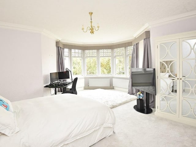 A large bay window floods this bedroom with natural light.