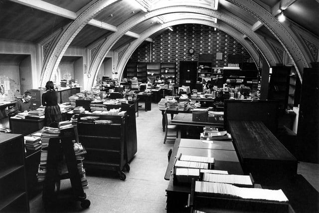 The cataloguing department located in the third floor office of Leeds Central Library. Staff, pictured in April 1984, are at work processing new stock for allocation to branches, Central and the Reference Library.