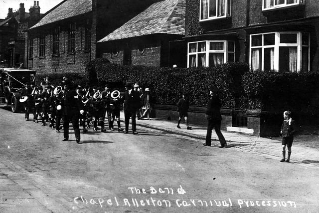 Chapel Allerton Carnival procession in June 1930. In front of the band is a policeman a decorated car is behind.