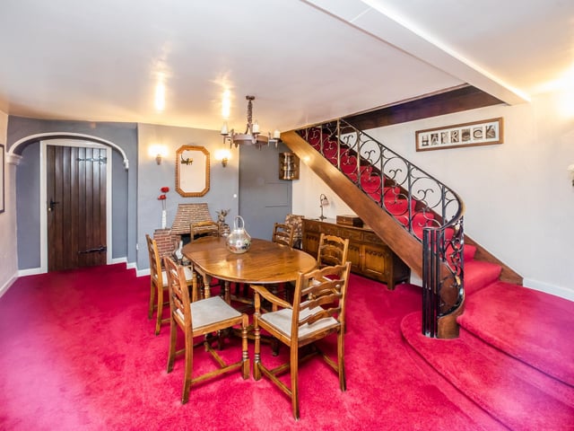 A stylish dining room , with feature staircase to the rear.