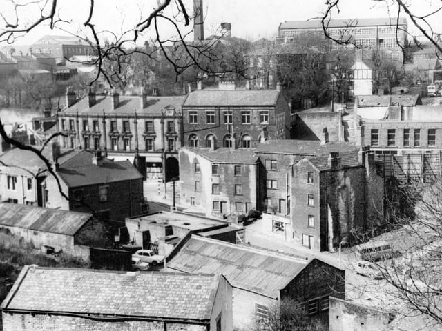 Morley Bottoms looking from Troy Road pictured in April 1967. Shops on Cheapside, Morley Bottoms can be seen to the left, one with a white awning outside. Prospect Mill can be seen in the background on the hill with chimneys to the left.