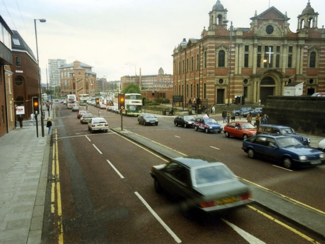 Looking west along The Headrow, towards Westgate, which begins after the junction with Oxford Place, located in front of Oxford Place Chapel. To the left of it, between the junctions of Oxford Row and Park Street is Leeds Combined Court Centre. The red brick building with large glass windows at the junction with Park Street and Park Lane is the Magistrates Court. Behind it the 1966 high rise residential block, Marlborough Towers is visible.