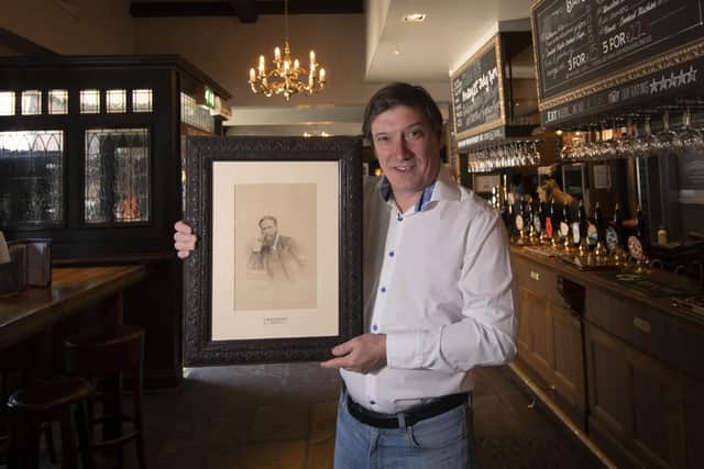 Toby Flint holding a photo of first landlord Henry Scarbrough.
