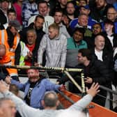AWAY END - A Leeds United fan interacts with stewards after falling onto the tv gantry during the Sky Bet Championship match between Hull City and Leeds United at MKM Stadium. Pic: George Wood/Getty Images