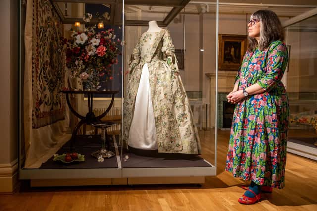 Caroline Newton, Assistant Curator of Decorative Arts for Leeds Museums & Galleries looking at the artefacts on display like a Sack back, open robe dress decorated with flowers, holly and berries. Picture: James Hardisty.