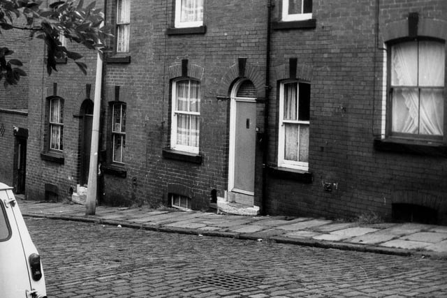 A row of back-to-back terraced houses on Leyburn Terrace in June 1973. On the left is a yard housing shared outside toilets.