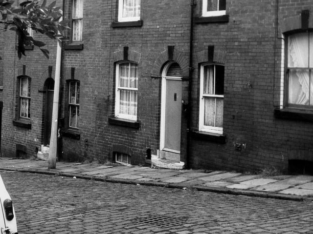 A row of back-to-back terraced houses on Leyburn Terrace in June 1973. On the left is a yard housing shared outside toilets.