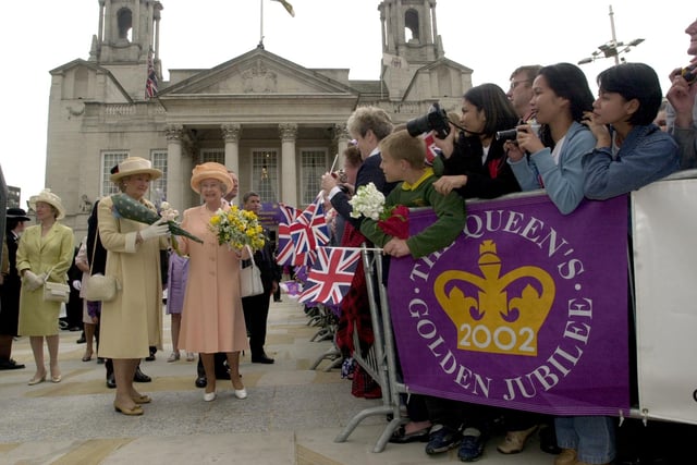 The Queen receives flowers from the crowds during a  walkabout in Millennium Square.