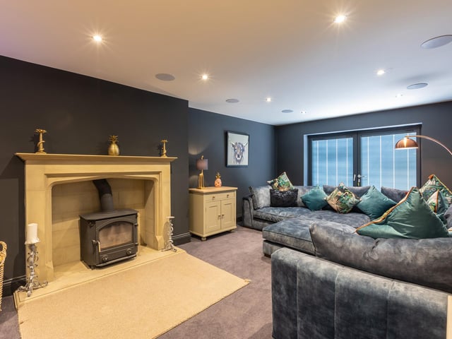 A large fireplace with stove is a focal point of this stunning room.