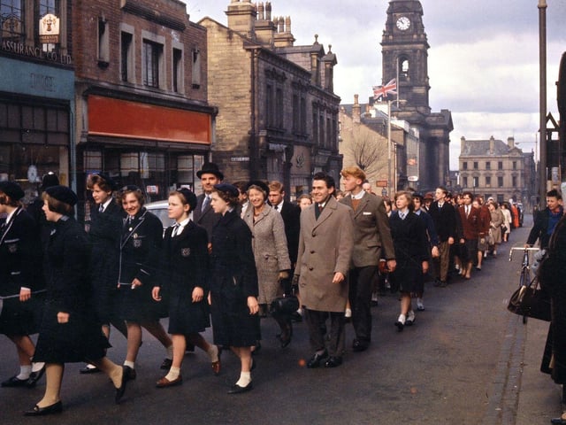 School contingents are seen here in the procession. The girls on the left are from Morley Grammar School, one of them being the daughter of the Vicar of Morley, Rosemary John. Behind them is a contingent from Woodkirk Secondary School led by three members of staff - Mr. F.E. Horsnail, Miss Jane Oddy and Mr. T. Jones; beyond this group there is the group from Victoria Secondary School - the new school at Bruntcliffe at this time was in the process of being built.