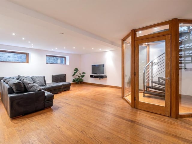 A spiral staircase from the dining kitchen leads to the lower ground floor which features a large family room that provides for a variety of purposes.