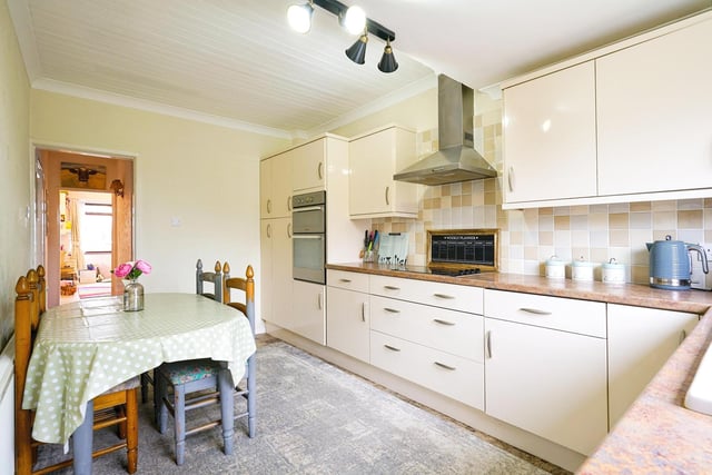 There is a large kitchen and diner with a porch that has space for a freestanding fridge.