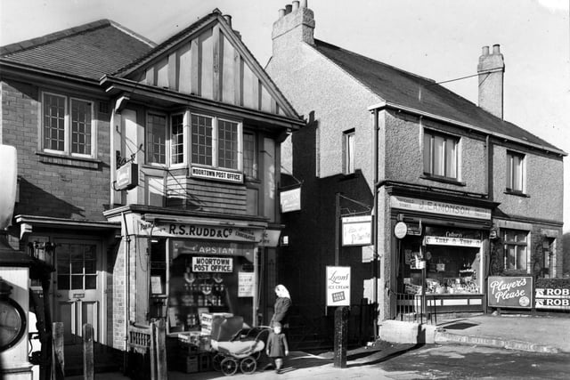 Shops on Harrogate Road in February 1952. Number 403 is R.S. Rudd, Newsagents and Postoffice. Number 405 is J. Eamonson, Household Stores. A woman with a child and pram stands outside. Advertisements on the shops are for Capstan tobacco, Lyons ice cream, Wills cigarettes, Players cigarettes and Cadbury's. A petrol pump is partly visible on the left.