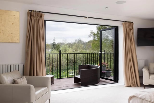 The main bedroom has bi folding doors opening onto a balcony with views over the garden.