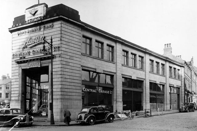Wade Lane in February 1949 showing Central Garage Ltd., an Austin cars dealer. It is a stone built building with large windows revealing cars for sale inside. Woodhouse Lane runs aong the left hand side of the garage. This is now the site of the St. John's Centre.