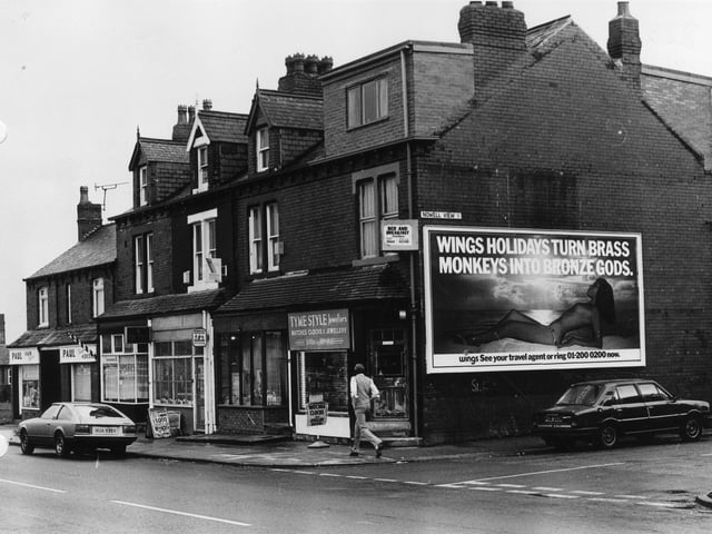 Harehills Lane showing a row of shops in March 1982. These include Tyme Style Jewellers, Anglia Building Society and Paul, hair stylist. The junction with Nowell View is on the right.
