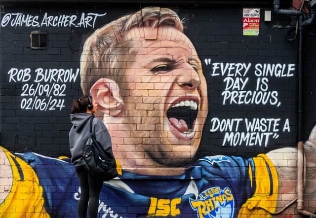 A student  admiring a mural of the late Leeds Rhinos player Rob Burrow in Leeds.