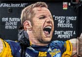 A student  admiring a mural of the late Leeds Rhinos player Rob Burrow in Leeds.