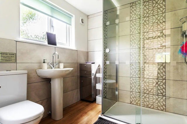 The bathroom is fitted with a walk-in shower, basin, toilet and storage cabinet.