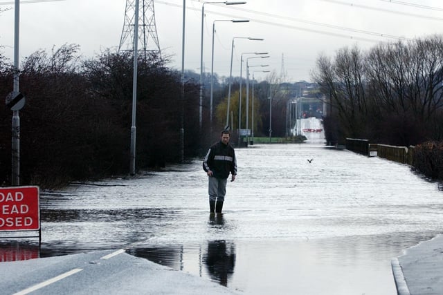 Barnsdale Road, Allerton Bywater, closed to traffic due to flooding. Father and son pictured venturing into the water to check the depth, on December 30, 2002.