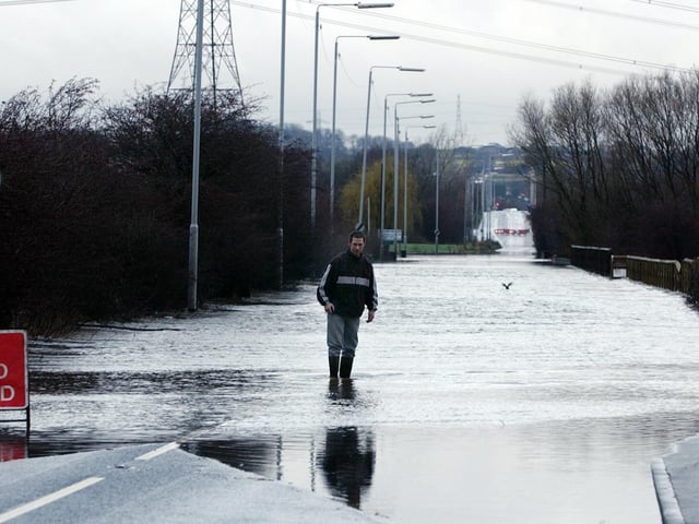 Barnsdale Road, Allerton Bywater, closed to traffic due to flooding. Father and son pictured venturing into the water to check the depth, on December 30, 2002.