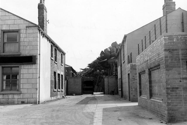 The west side of Moor Road, showing the yard of James Robinson, scrap metal dealer. The view looks between two buildings at a very large pile of scrap metal. Pictured in June 1950.