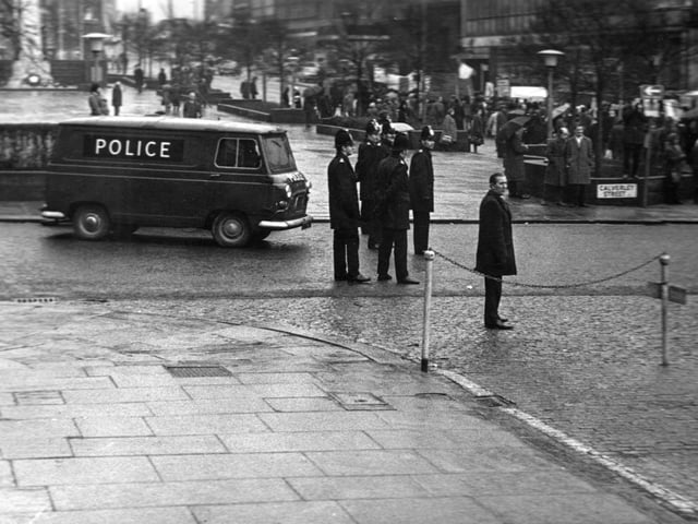 A view east along The Headrow from the junction with Calverley Street showing a police presence accompanying a march of solidarity with the people of Northern Ireland.