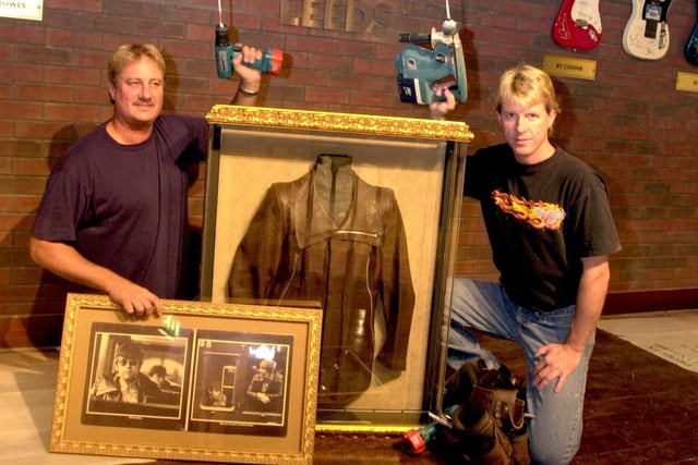 Installers David Holle and John Kalicak with some of the memorabilia ready for hanging at the new Hard Rock Cafe.