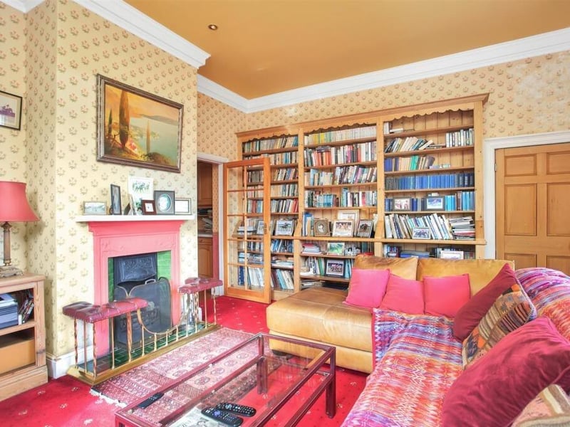 The cosy sitting room includes a feature fireplace.