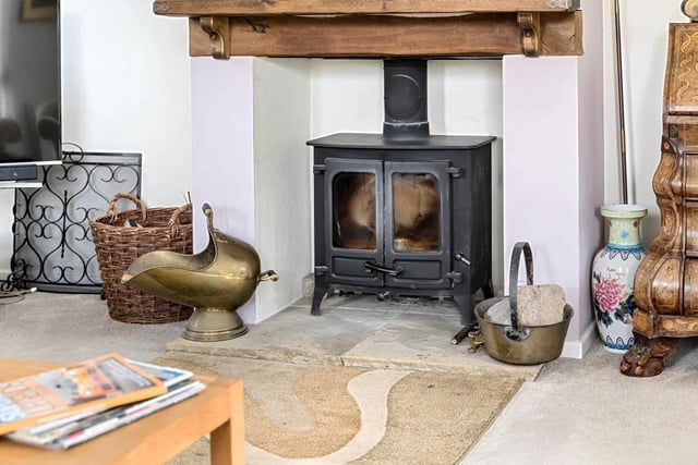 The living room also features a wonderful central fireplace housing a wood burning stove.