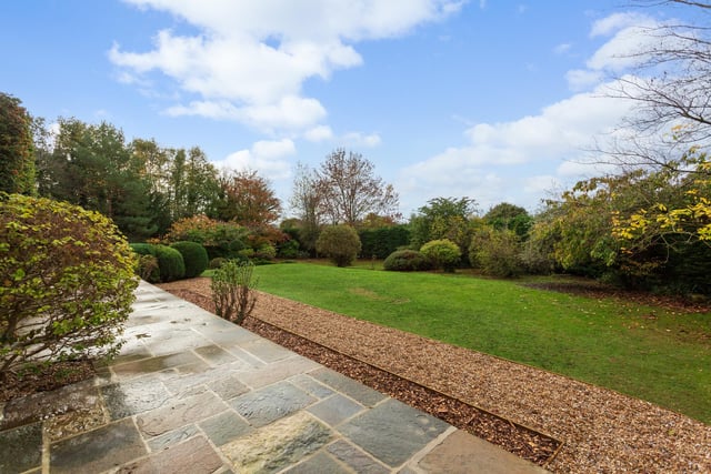 Externally the property stands in a private plot of around 0.65 acres, surrounded by mature, manicured gardens. The large southerly facing patio provides the ideal entertaining space with steps leading down to a lawned area flanked by clipped box hedging and trees.