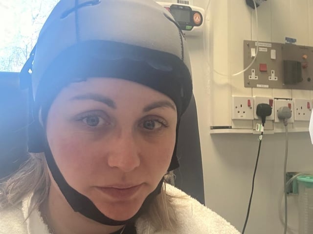 Olivia Drury using a "cold cap" during treatment.