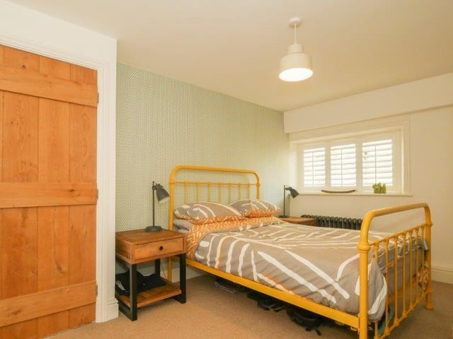 To the first floor, there are two bedrooms and a house bathroom. Bedroom one is a generous double sized room with exposed original wooden beams, recessed fireplace, fitted wardrobes and stairs leading to a mezzanine level with eaves storage and Velux window, currently being used as an additional living room.