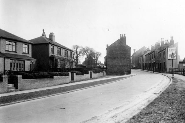 A view up Wesley Street with brick semi detached houses followed by brick terraces in April 1951.