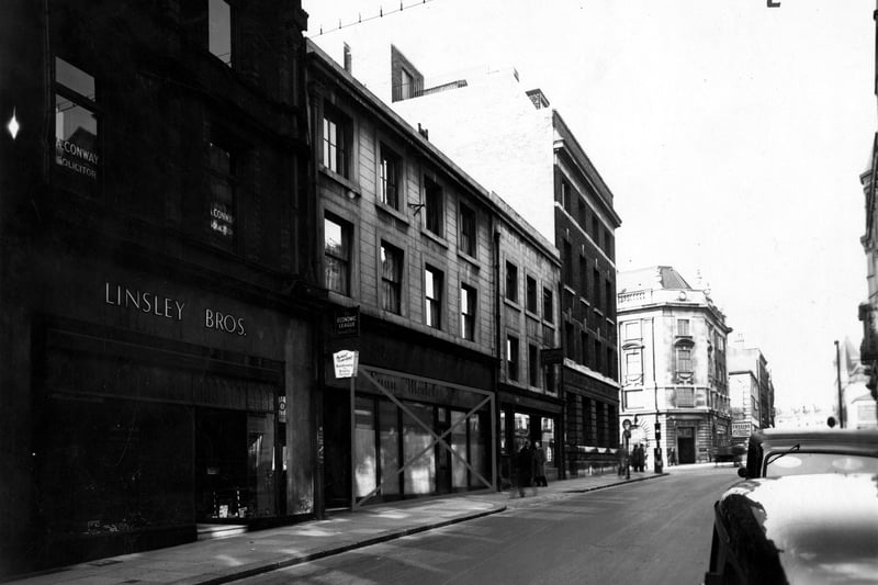 Albion Street in April 1951. In view are Linsley Bros., gun makers (with A. Conway, solicitors, above), The Economic Leagues' offices and an empty Lynn Models Ltd, which has a cross painted through it. Also in focus is James Charles Son & Carter, estate agents and The Leeds & Holbeck Building Society, at the junction with The Headrow.