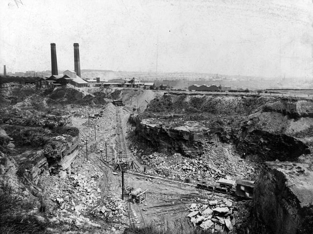 An aerial view of Bramley brickworks and quarries in July 1938. Narrow gauge railway with factory hoppers runs along the bottom. Factory buildings and chimneys in the background.