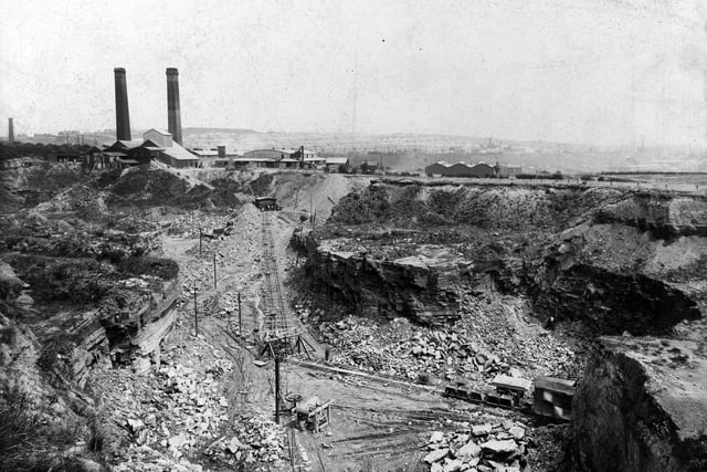 An aerial view of Bramley brickworks and quarries in July 1938. Narrow gauge railway with factory hoppers runs along the bottom. Factory buildings and chimneys in the background.
