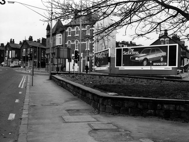 Roundhay Road, left, at the junction with Roseville Road (where advertising billboards are displayed). From the shop on the left, properties are numbered 158 to 148. Homes in Bayswater Place are visible in the background, right. Pictured in April 1980.
