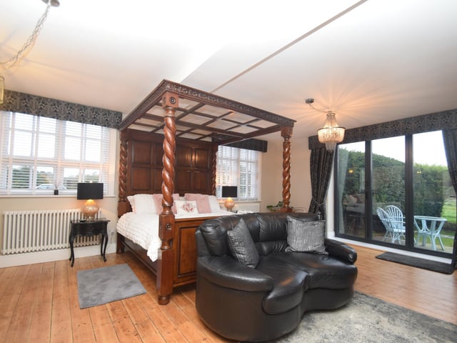 One of the double bedrooms, with access to a patio and the gardens.
