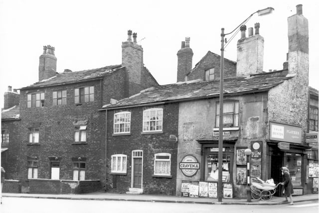 The junction of Amberley Road and Tong Road in May 1965. Number 77 Amberley Road can be seen on the left, a three storey building. Moving right, number 79, then number 99 Tong Road, a sweet and tobacco shop and newsagents, business of E.H. and D. Brunton. Posters advertise various magazines and newspapers including an article on Face Lifts for Men in Reveille.