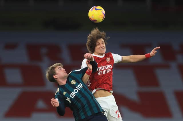 David Luiz of Arsenal wins a header over Patrick Bamford of Leeds United during the Premier League match between Arsenal and Leeds United at Emirates Stadium on February 14, 2021.