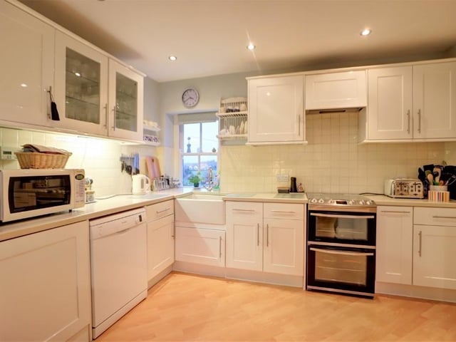 In the modern, bright kitchen with fitted units and laminate worktops is an integrated fridge and plumbing for a dishwasher..